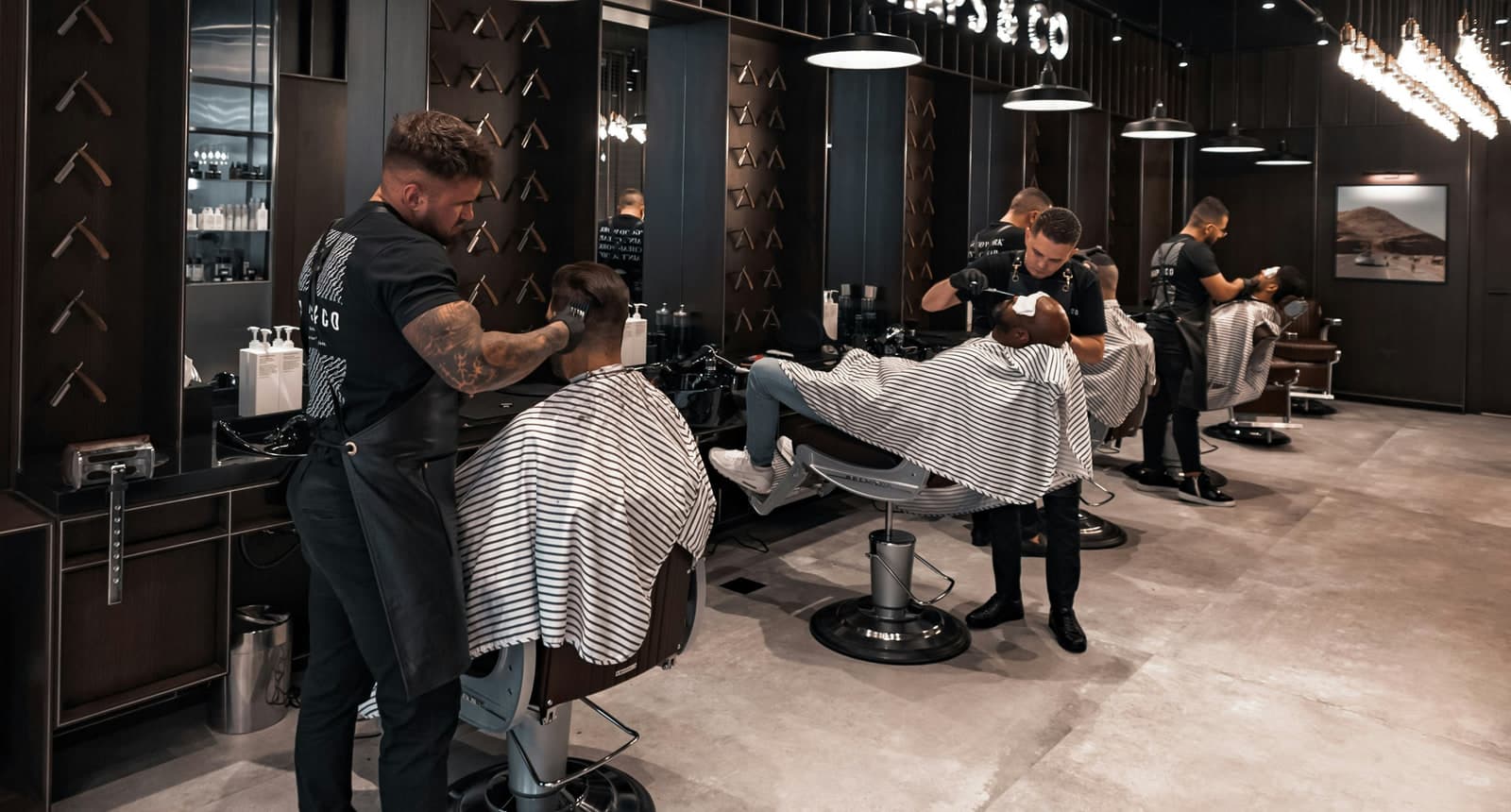 Several barbers serving clients side by side